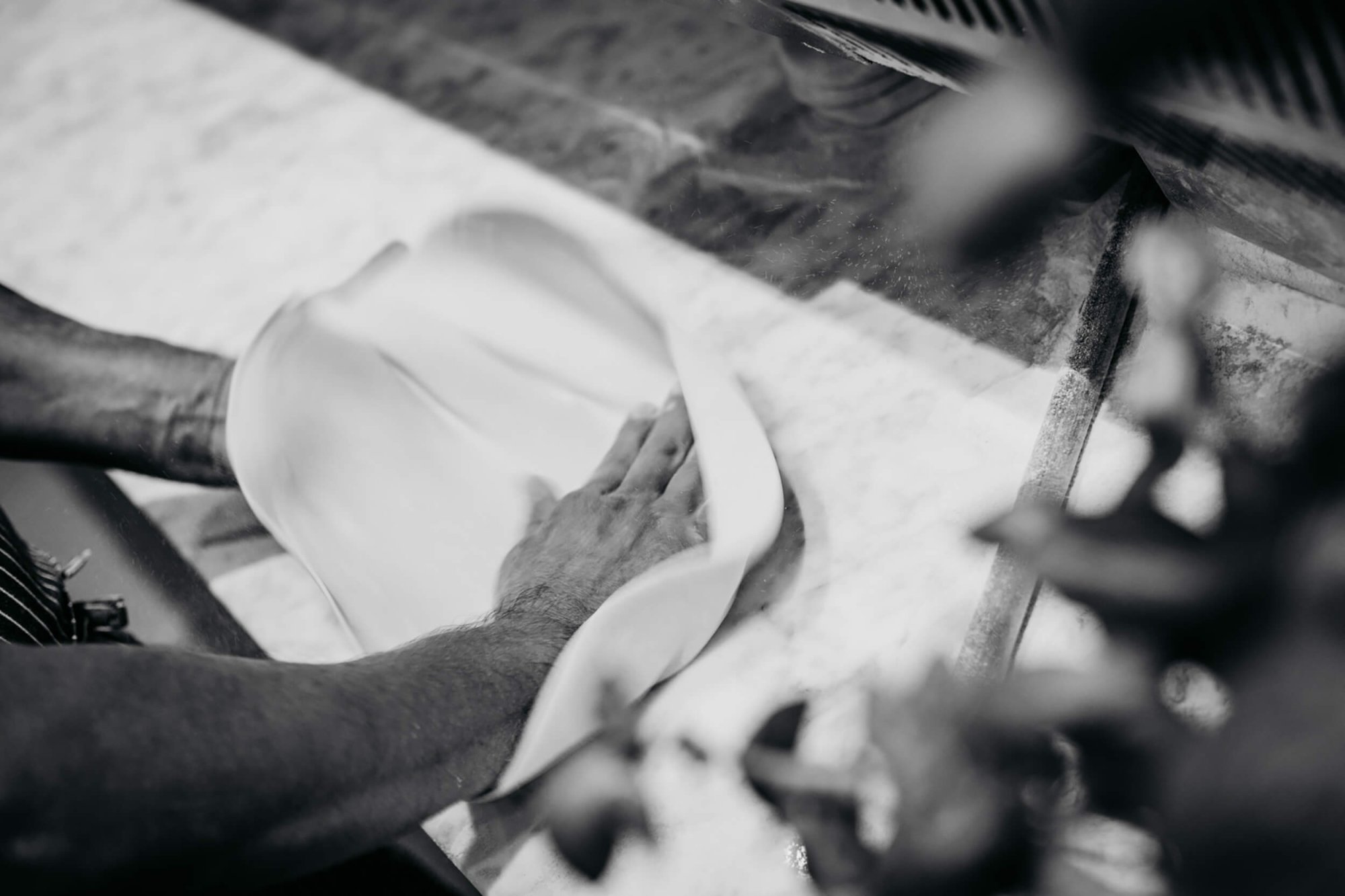 Hands kneading pizza dough.